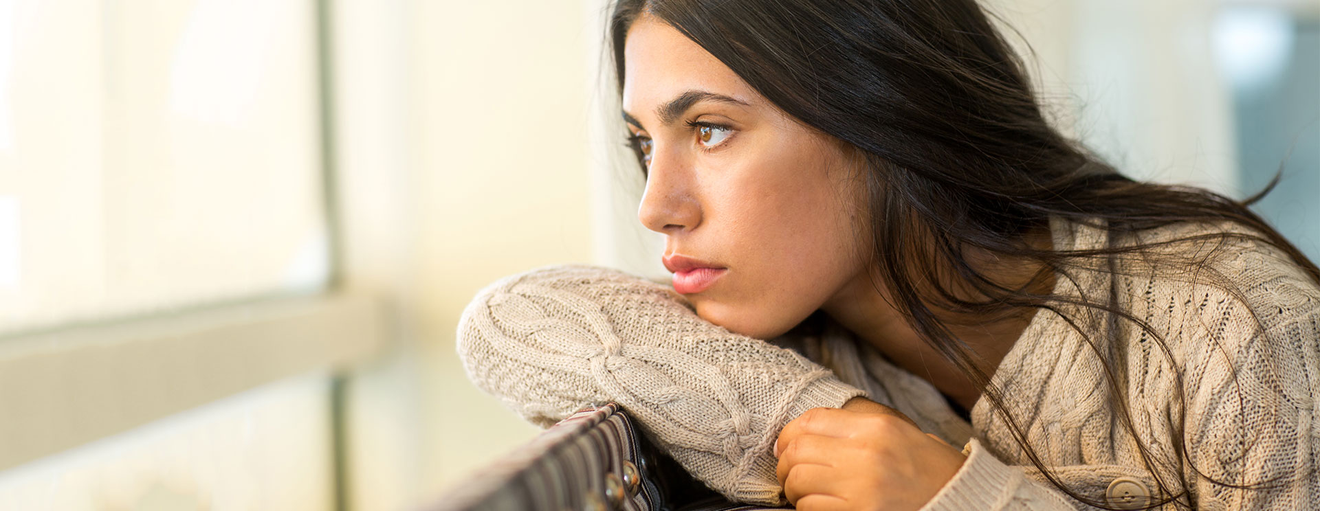 A woman looking out the window thinking about adoption